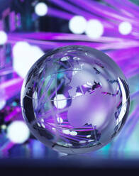 Fibre optics reflected on glass globe against colored background - ABRF01066