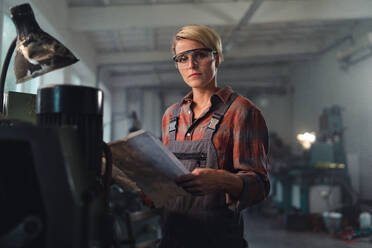 Ein Porträt einer jungen Frau, die in einer Metallwerkstatt arbeitet. - HPIF08349