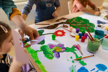 Cloe-up von kleinen Kindern bei der Arbeit an einem Projekt mit einem Lehrer während des kreativen Kunst- und Handwerksunterrichts in der Schule - HPIF08470