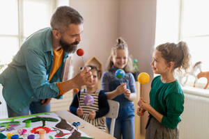 Eine Gruppe kleiner Kinder arbeitet mit ihrem Lehrer an einem Projekt während des kreativen Kunst- und Handwerksunterrichts in der Schule. - HPIF08473