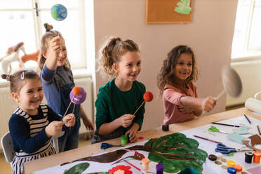 Eine Gruppe kleiner Kinder arbeitet an einem Projekt während des kreativen Kunst- und Handwerksunterrichts in der Schule. - HPIF08478