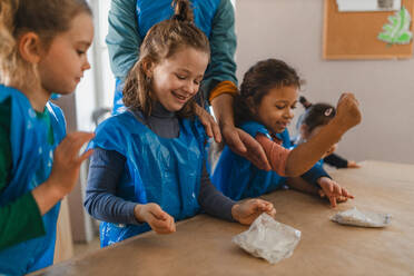 A group of little kids working with pottery clay during creative art and craft class at school. - HPIF08488