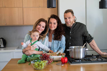 Glückliche Mehrgenerationenfamilie zu Hause, die in der Küche einen Gemüsesalat zubereitet. - HPIF08542
