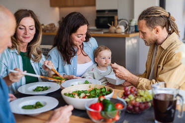 Eine glückliche Mehrgenerationenfamilie, die zu Hause ein gesundes Mittagessen zu sich nimmt. - HPIF08548