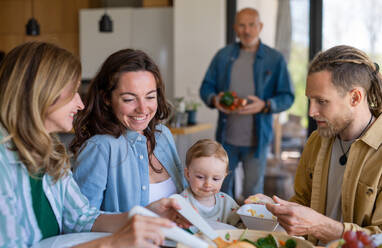 Eine glückliche Mehrgenerationenfamilie, die zu Hause ein gesundes Mittagessen zu sich nimmt. - HPIF08549