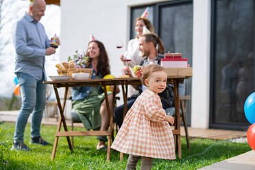 Ein kleines Kleinkind mit Eltern und Großeltern draußen im Garten zu Hause, Geburtstagsfeier Party. - HPIF08569