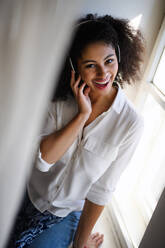 A portrait of young woman with headphones indoors at home, listening to music. - HPIF08698