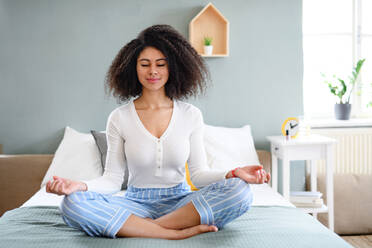Porträt einer entspannten jungen Frau, die zu Hause Yogaübungen macht. - HPIF08713