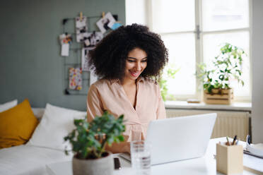 Happy young woman student with laptop working indoors at home, home office concept. - HPIF08741