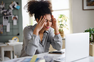 Frustrierte junge Frau mit Laptop arbeitet drinnen zu Hause, Home-Office-Konzept. - HPIF08749