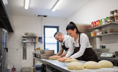 Ein Koch und eine Köchin arbeiten in der Küche eines Restaurants an ihren Gerichten. - HPIF08762