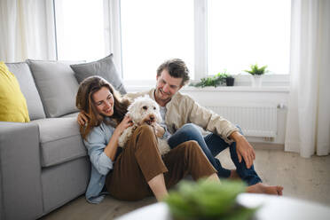 Ein glückliches, verliebtes junges Paar mit Hund, das sich zu Hause ausruht. - HPIF08824
