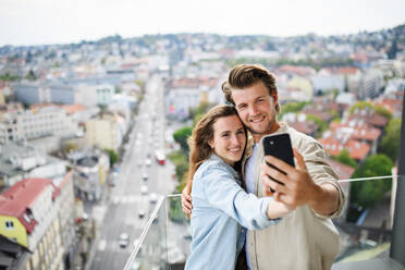 Ein glückliches Paar hält seine Liebe mit der Kamera fest und posiert für ein Selfie auf dem heimischen Balkon - HPIF08833
