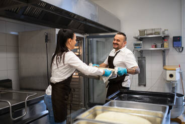 Ein Koch und eine Köchin arbeiten in der Küche eines Restaurants an ihren Gerichten. - HPIF08916