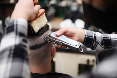 Rückansicht eines männlichen Kunden, der einen Friseur in einem Friseursalon besucht. - HPIF08947