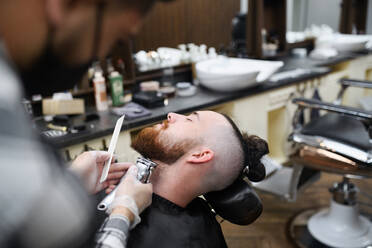 Ein junger Mann besucht einen Friseur in einem Friseursalon, Mittelteil und Nahaufnahme. - HPIF08995