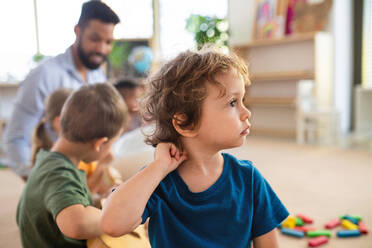 Ein Porträt eines kleinen Jungen mit Klassenkameraden und Lehrer in einem Klassenzimmer. - HPIF09020