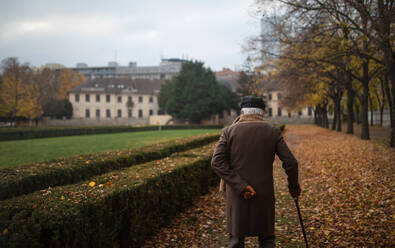 Ein alter eleganter Mann mit Spazierstock auf Spaziergang im Park am Herbsttag - HPIF09103