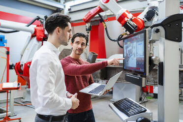 Techniker diskutieren gemeinsam in der Roboterfabrik - DIGF19779