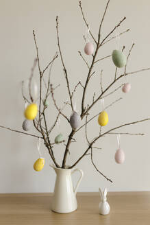 Easter eggs hanging on twigs in vase at home - VIVF00415