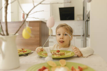 Nettes Mädchen isst Pfannkuchen zum Frühstück zu Hause - VIVF00431