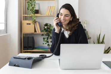 Lächelnde Geschäftsfrau beim Telefonieren im Büro - XLGF03272