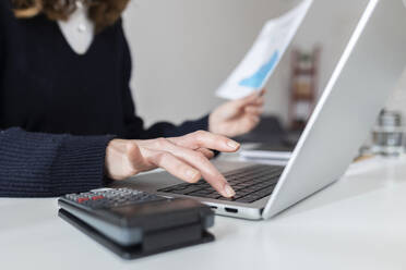 Businesswoman using laptop at desk - XLGF03291