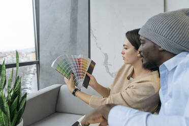 Multiracial designers choosing colors at office - OSF01417