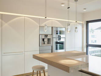 Pendant lights on kitchen island in modern apartment - RORF03426