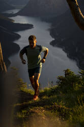 Sportsman jogging on mountain at sunset - MALF00434