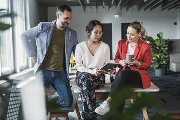 Multiracial business colleagues planning over tablet PC at office - UUF28379