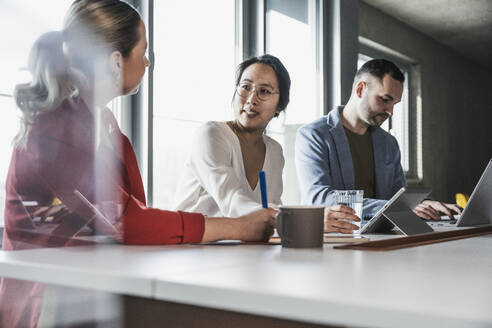 Geschäftsfrauen mit Kollegenplanungsstrategie am Arbeitsplatz - UUF28383