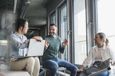 Businessman gesturing in meeting with colleagues at office - UUF28430