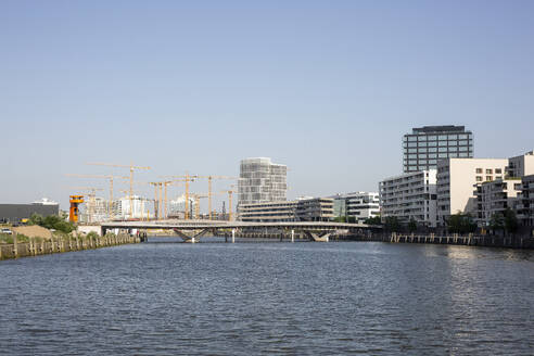 Deutschland, Hamburg, Elbe fließt durch die HafenCity mit Brücke und Großbaustelle im Hintergrund - ASCF01732