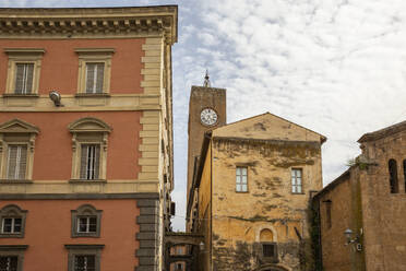 Torre del Moro and Palazzo Conte Bracci buildings under cloudy sky in Orvieto, Italy - MAMF02606