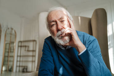 Nachdenklicher älterer Mann mit grauem Haar sitzt zu Hause - MDOF00821