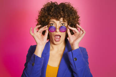 Woman with sunglasses against magenta background - JSMF02728