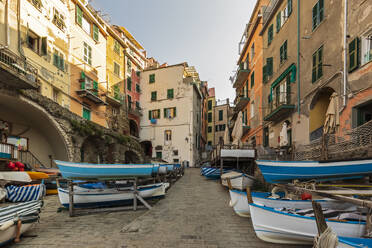 Italien, Ligurien, Riomaggiore, Boote liegen entlang der leeren Straße der Küstenstadt entlang der Cinque Terre - FOF13528