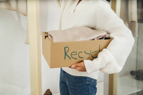 Young woman with clothes in recycle box - VPIF07906
