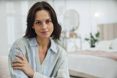 Smiling young woman in bedroom at home - VPIF07939