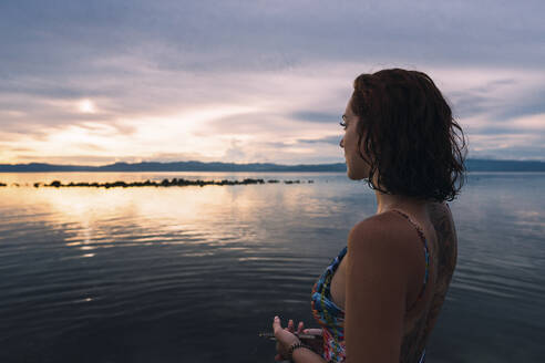 Thoughtful woman standing at beach - PNAF05017