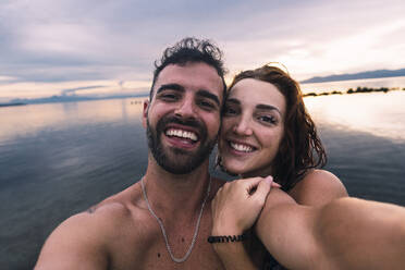 Glückliches Paar nimmt Selfie zusammen am Strand - PNAF05021