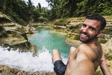 Glücklicher Mann nimmt Selfie von Wasserfall - PNAF05029