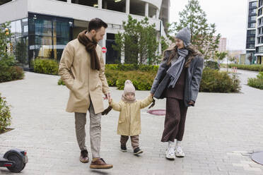 Mother and father with cute son walking on footpath - SEAF01782