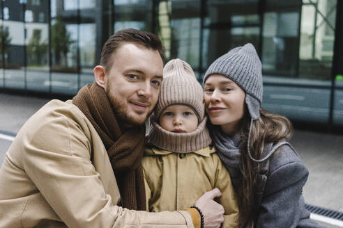 Lächelnde Mutter und Vater umarmen ihren Sohn - SEAF01787