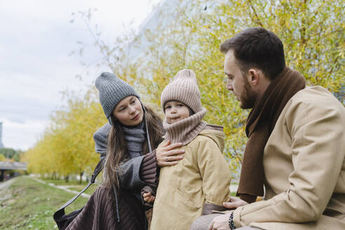 Mutter und Vater mit Sohn vor einem Baum sitzend - SEAF01807