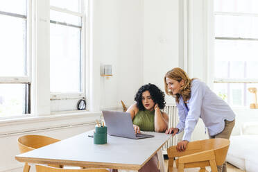 Kreative Geschäftsfrauen besprechen in einer Besprechung am Laptop ihre Strategie - CAVF96617