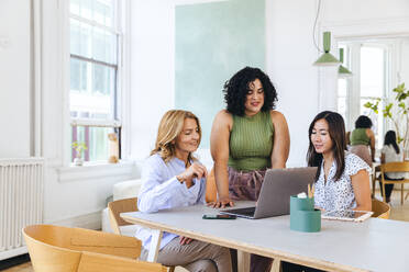 Smiling multiracial colleagues during meeting in creative office - CAVF96635