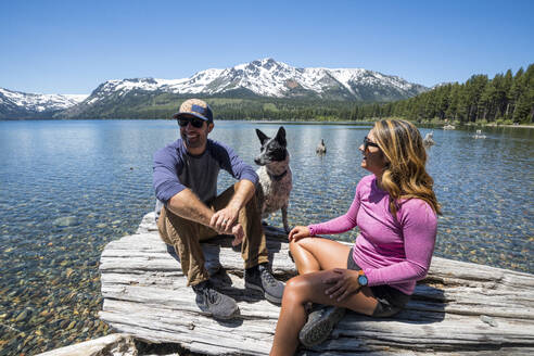 Ein Paar entspannt sich mit seinem Hund am Ufer des Fallen Leaf Lake. - CAVF96650