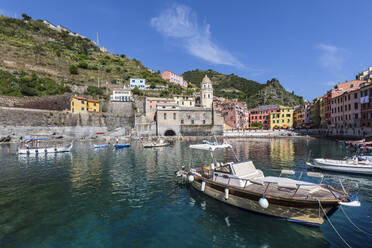Italy, Liguria, Vernazza, Edge of coastal town along Cinque Terre with boats moored in foreground - FOF13545